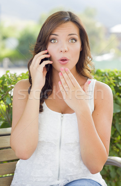 Stock photo: Shocked Young Adult Female Talking on Cell Phone Outdoors