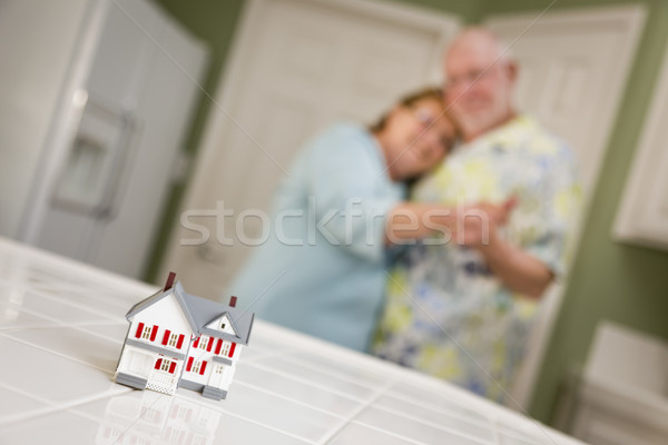 Senior Adult Couple Gazing Over Small Model Home on Counter Stock photo © feverpitch