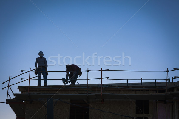 Construction Workers Silhouette on Roof Stock photo © feverpitch