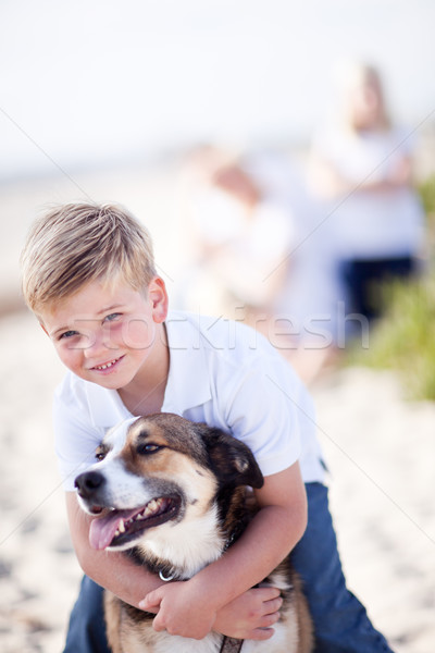Jóképű fiatal srác játszik kutya tengerpart boldog Stock fotó © feverpitch