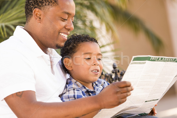 Métis père en fils lecture parc brochure à l'extérieur Photo stock © feverpitch