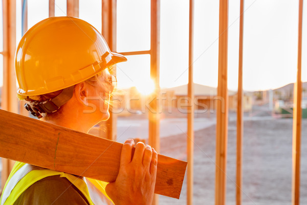 Female Construcion Worker Looking Out From New Home Framing Stock photo © feverpitch