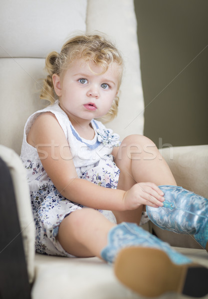 Blonde Haired Blue Eyed Little Girl Putting on Cowboy Boots Stock photo © feverpitch