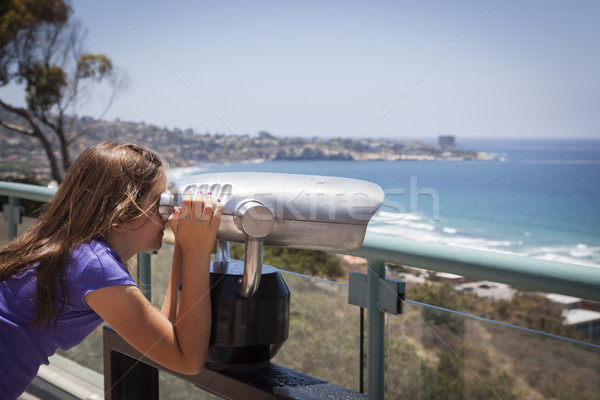 Young Girl Looking Out Over the Pacific Ocean with Telescope Stock photo © feverpitch