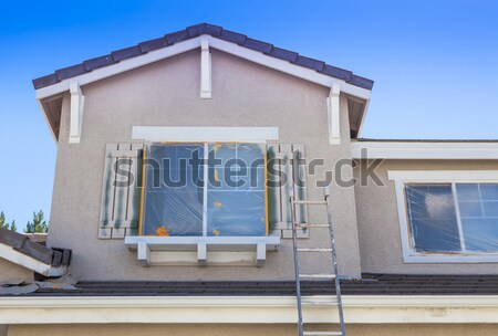 Stock photo: House Painter Painting the Trim And Shutters of Home