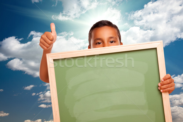Proud Hispanic Boy Holding Blank Chalkboard Over Sky Stock photo © feverpitch