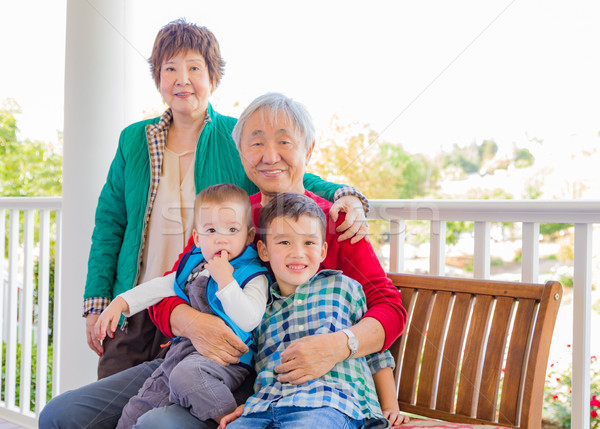 Senior Adult Chinese Couple Sitting With Their Mixed Race Grandc Stock photo © feverpitch