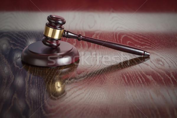 Wooden Gavel Resting on Flag Reflecting Table Stock photo © feverpitch