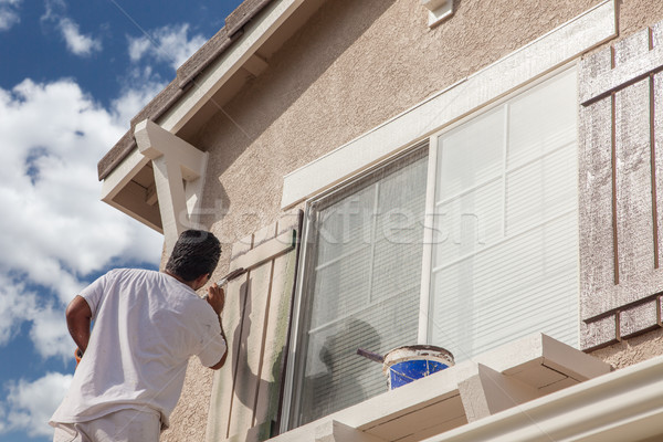 Stock photo: Professional House Painter Painting the Trim And Shutters of A H