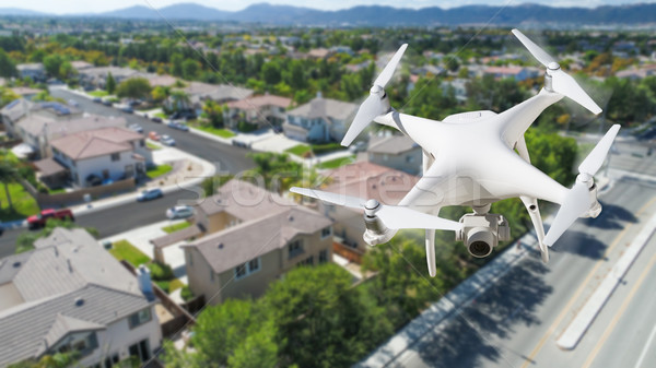 Unmanned Aircraft System (UAV) Quadcopter Drone In The Air Over  Stock photo © feverpitch