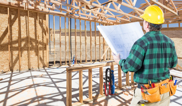 Contractor with hard Hat and Plans Standing Inside Construction  Stock photo © feverpitch