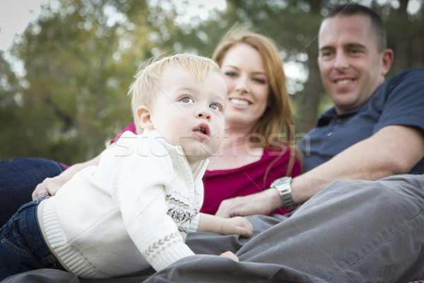 Cute Child Looks Up to Sky as Young Parents Smile Stock photo © feverpitch
