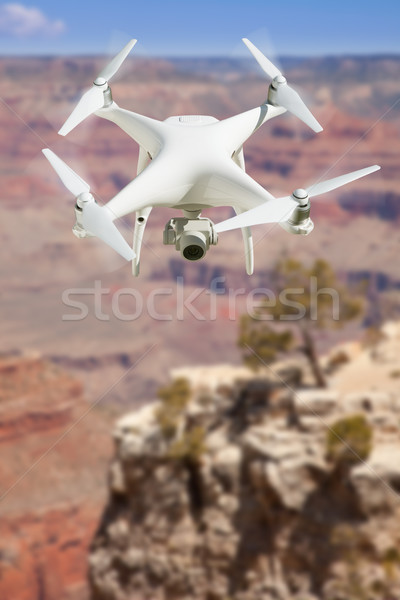 Unmanned Aircraft System (UAV) Quadcopter Drone In The Air Over  Stock photo © feverpitch