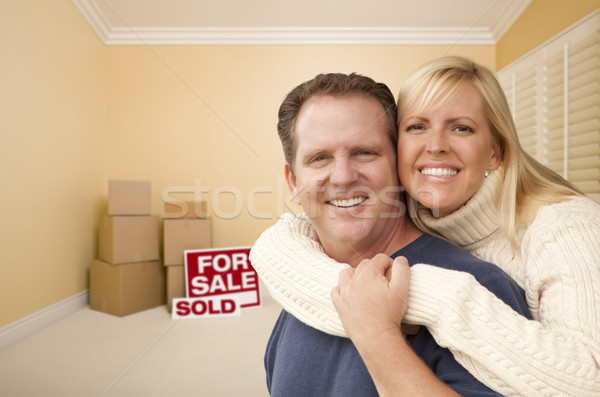 Couple in New House with Boxes and Sold Sale Sign Stock photo © feverpitch