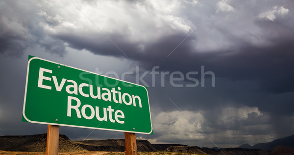 Stock photo: Evacuation Route Green Road Sign and Stormy Clouds