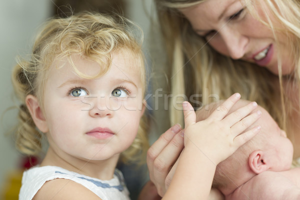 Young Mother Holds Newborn Baby Girl as Young Sister Looks Stock photo © feverpitch