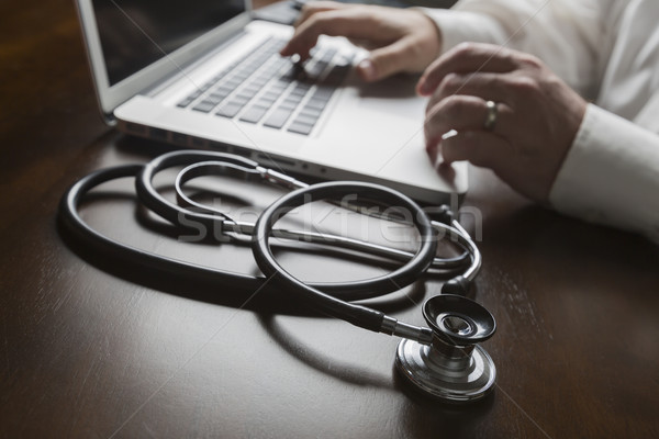 Stethoscope near Man Typing on Laptop Computer Stock photo © feverpitch