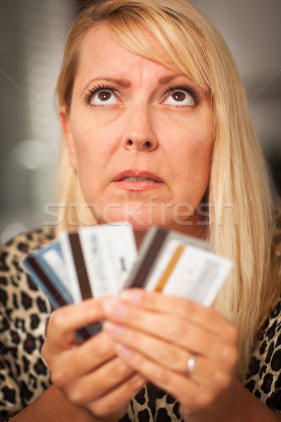 Upset Woman Glaring At Her Many Credit Cards Stock photo © feverpitch