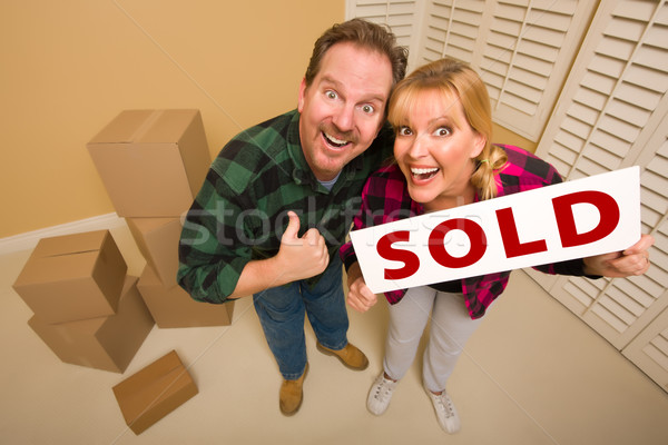 Goofy Couple Holding Sold Sign Surrounded by Boxes Stock photo © feverpitch
