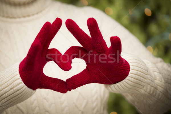 Stock photo: Woman Wearing Red Mittens Holding Out a Heart Hand Sign