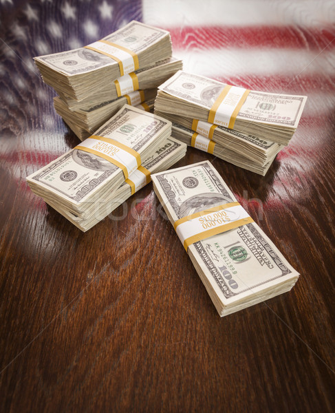 Stock photo: Thousands of Dollars with Reflection of American Flag on Table