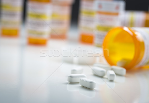 Medicine Bottles Behind Pills Spilling From Fallen Bottle Stock photo © feverpitch