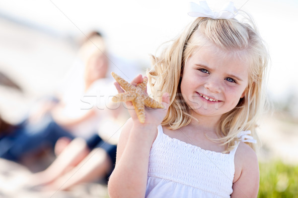 Adorable peu fille starfish plage Photo stock © feverpitch