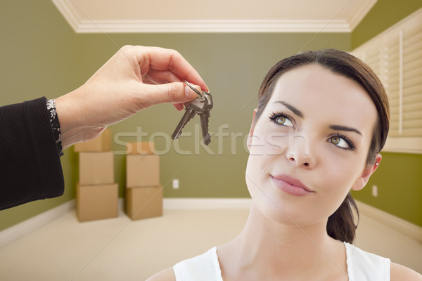 Young Woman Being Handed Keys in Empty Room with Boxes Stock photo © feverpitch