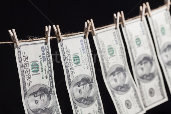 Hundred Dollar Bills Hanging From Clothesline on Dark Background Stock photo © feverpitch