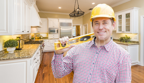 Stock photo: Contractor with Level Wearing Hard Hat Standing In Custom Kitche