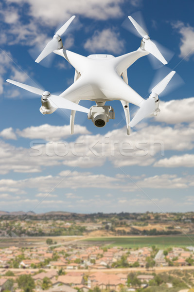 Unmanned Aircraft System (UAV) Quadcopter Drone In The Air Over  Stock photo © feverpitch