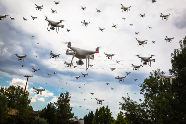 Dozens of Drones Swarm in the Cloudy Sky. Stock photo © feverpitch