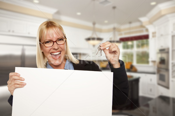 Stock photo: Young Woman Holding Blank Sign and Keys Inside Kitchen