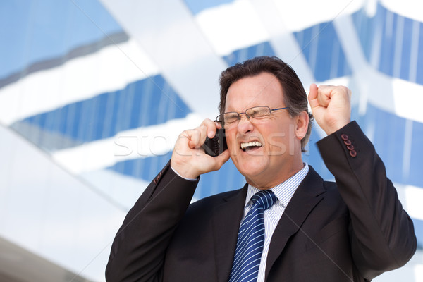 Excited Businessman on Cell Phone Stock photo © feverpitch