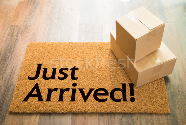 Just Arrived Welcome Mat On Wood Floor With Shipment of Boxes Stock photo © feverpitch