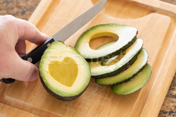 Male Hand Prepares Fresh Cut Avocado With Heart Shaped Pit Area  Stock photo © feverpitch