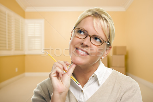 Daydreaming Woman with Pencil in Empty Room and Boxes Stock photo © feverpitch