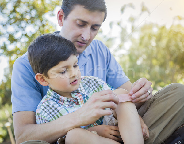 Loving Father Puts Bandage on Knee of Young Son Stock photo © feverpitch