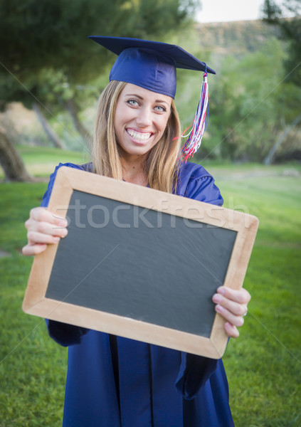 Woman Holding Diploma and Blank Chalkboard Wearing Cap and Gown Stock photo © feverpitch