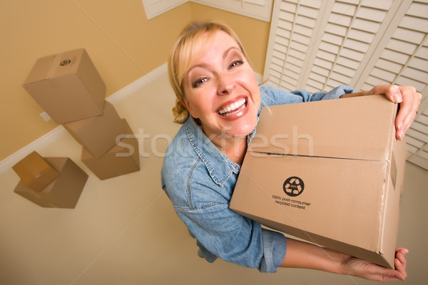 Excited Woman Holding Moving Boxes in Empty Room Stock photo © feverpitch