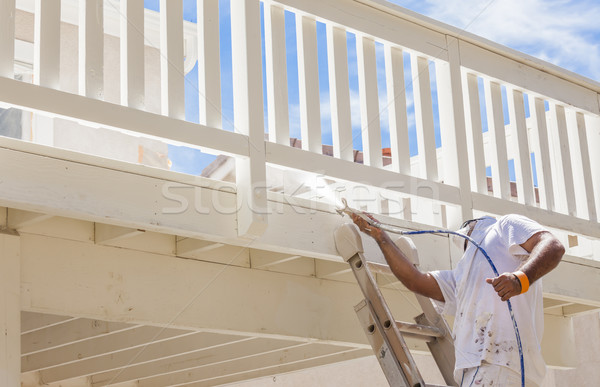 House Painter Spray Painting A Deck of A Home Stock photo © feverpitch
