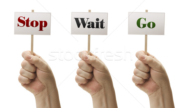 Three Signs In Fists Saying Stop, Wait and Go Stock photo © feverpitch