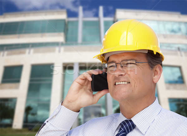 Contractor in Hardhat Talks on Phone In Front of Building Stock photo © feverpitch