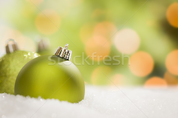 Green Christmas Ornaments on Snow Over an Abstract Background Stock photo © feverpitch