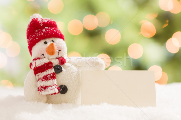 Stock photo: Cute Snowman with Blank White Card Over Abstract Background