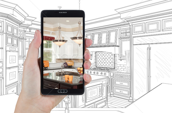 Hand Holding Smart Phone Displaying Photo of Kitchen Drawing Beh Stock photo © feverpitch