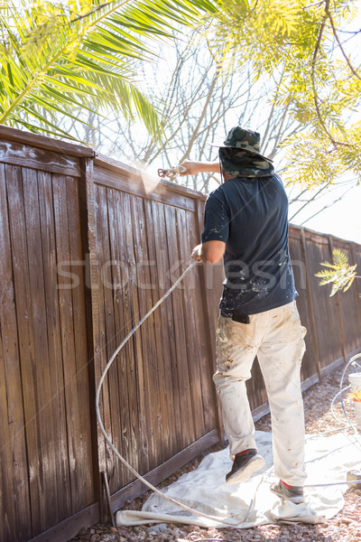 Professional Painter Spraying Yard Fence with Stain Stock photo © feverpitch