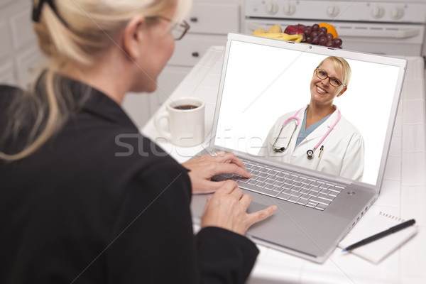 Femme cuisine utilisant un ordinateur portable ligne infirmière médecin Photo stock © feverpitch
