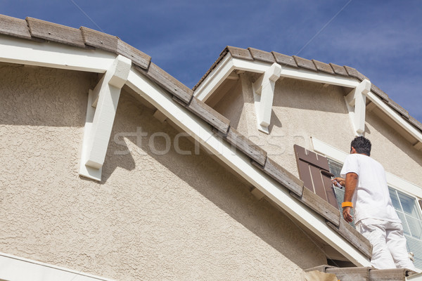 Stock photo: House Painter Painting the Trim And Shutters of Home