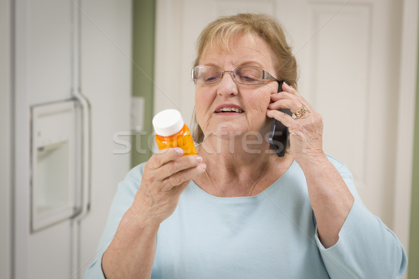 Senior Adult Woman on Cell Phone Holding Prescription Bottle Stock photo © feverpitch